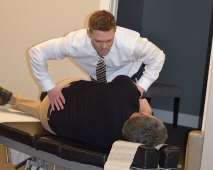 Male chiropractor treating his patient