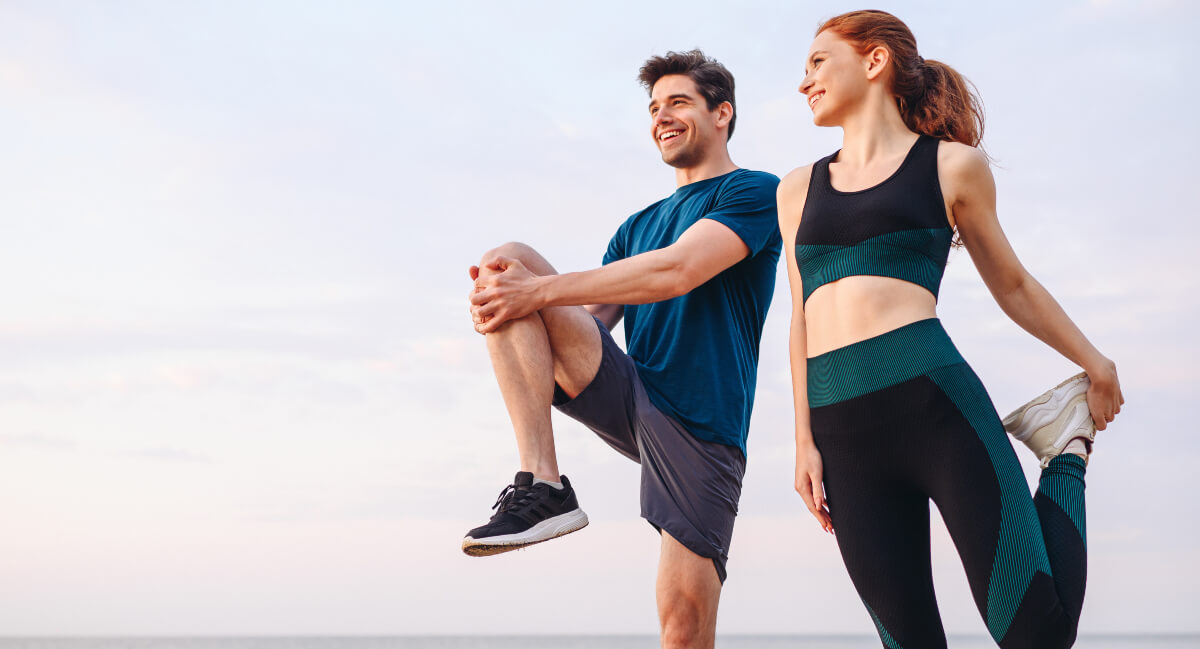 Male and female athletes stretching