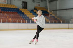 Young figure skater gliding on indoor ice rink. Perfect for sports or lifestyle themes.