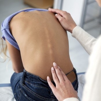 doctor examining a child's spine