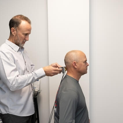 chiropractor adjusting patients neck using a toom