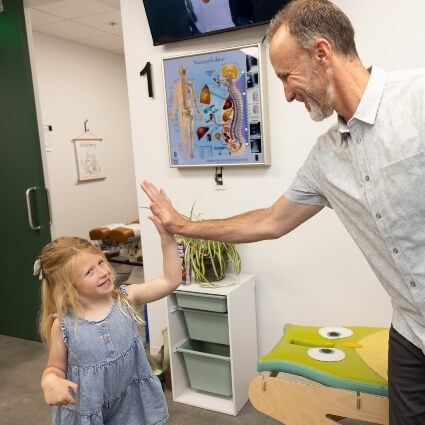 our chiropractor high-fiving a patient