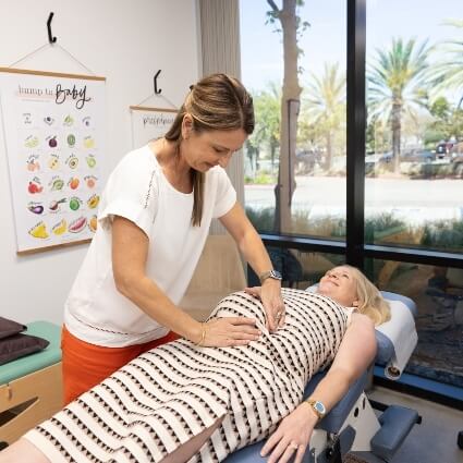 chiropractor adjusting pregnant patients stomach