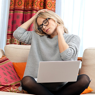 Woman sitting at her laptop with neck pain