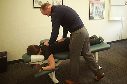 Dr. Baker adjusting a patient's upper back