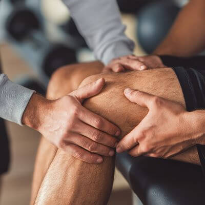 Chiropractor examining a patient's knee in an emergency appointment
