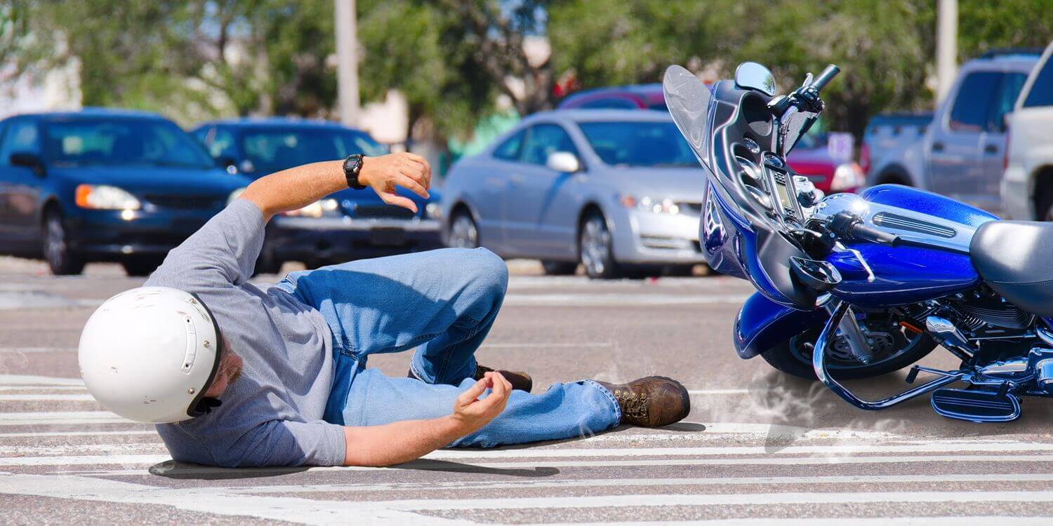 Man laying on the ground after getting in a motorcycle accident