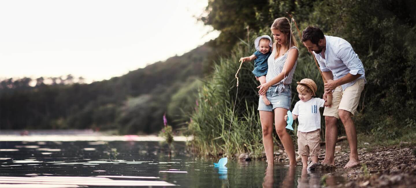 happy family playing near a lake