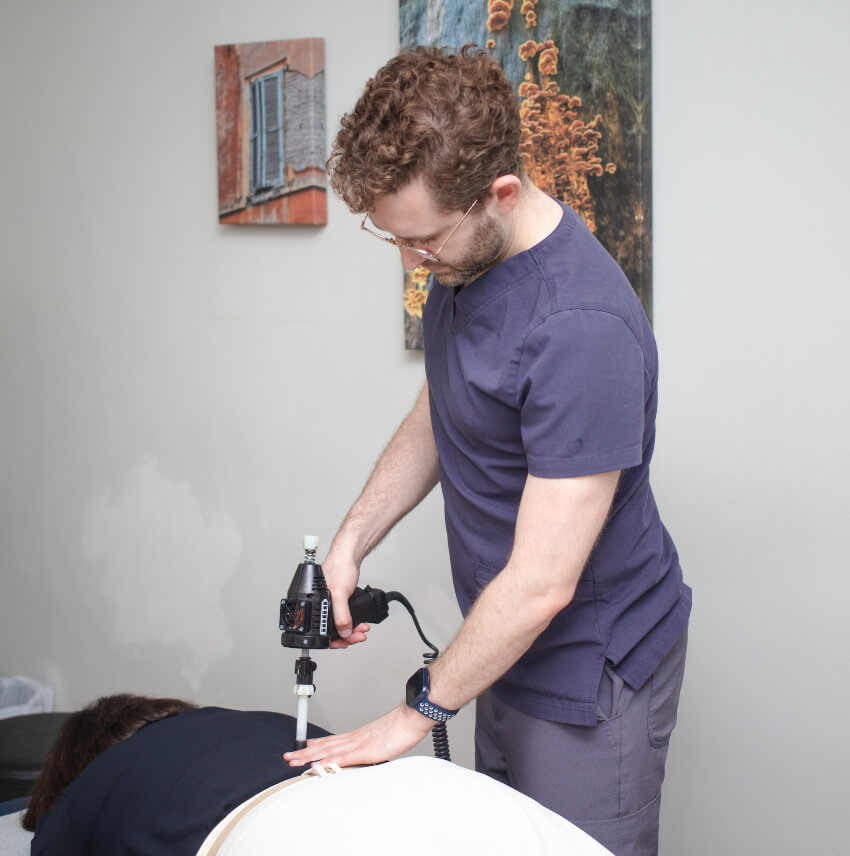 Dr Ben adjusting patient with tool