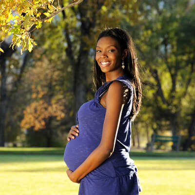 Pregnant woman standing outdoors in park