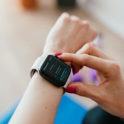 Woman checks her fitness data on a smartwatch, highlighting wellness.