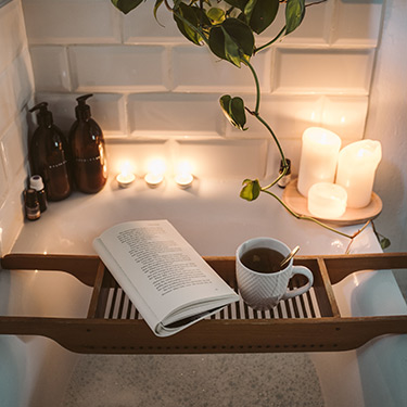 relaxing bath with candles and a book