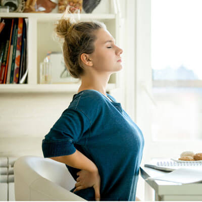 woman sitting at a desk with back pain