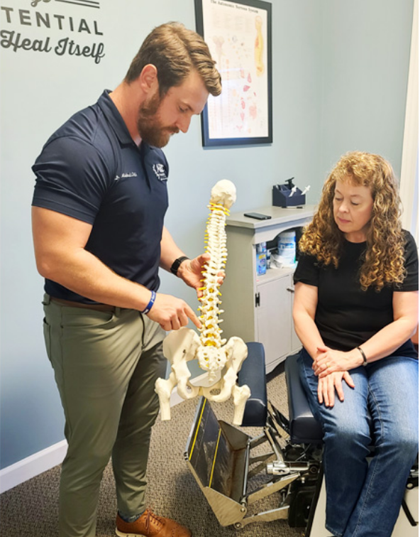 doctor showing spine model to patient
