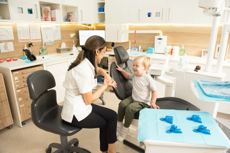 Dr Bhatla with little boy in dental chair