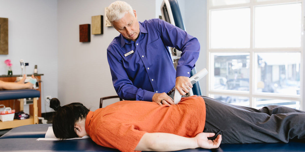 Dr. Shepherd adjusting a patient using an Activator instrument.