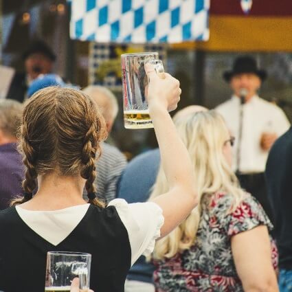 person raising a beer at oktoberfest