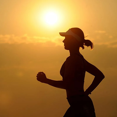 woman running on sunset backdrop