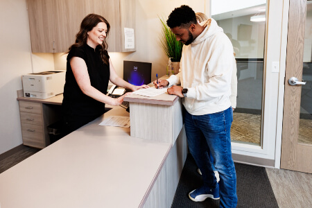 Male patient checking in at reception