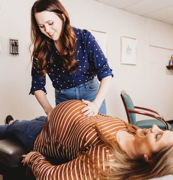 Chiropractor adjusting pregnant lady