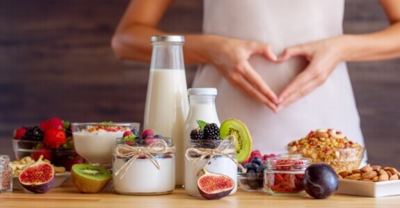 woman with heart hands over stomach