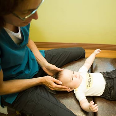 Dr. Elizabeth with hands on babys head