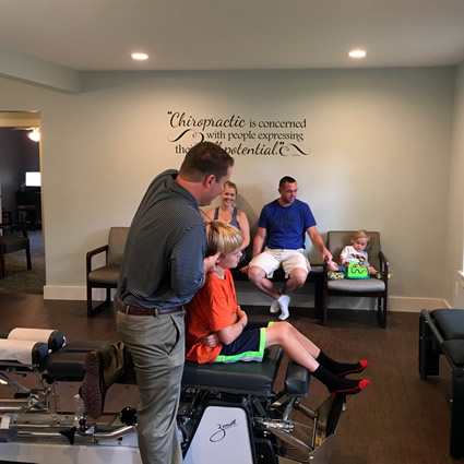 Dr. Steve adjusting boy sitting on table