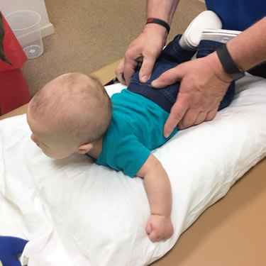 Dr Massey adjusting babys hips
