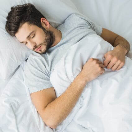 man sleeping peacefully in bed