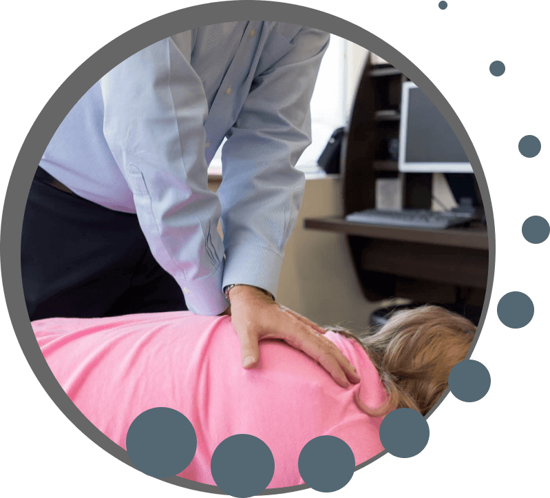 chiropractor adjusting a patient with a tool