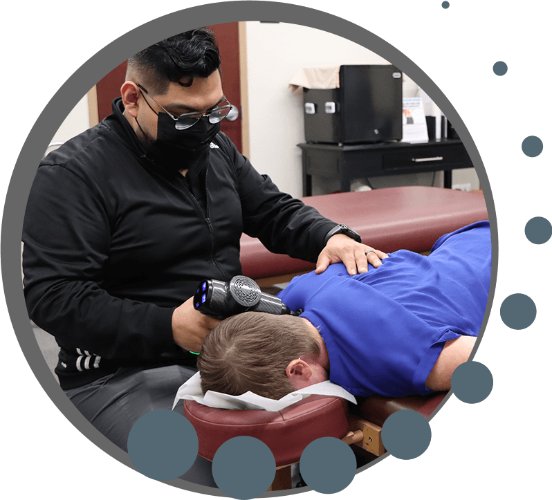 chiropractor adjusting a patient with a tool