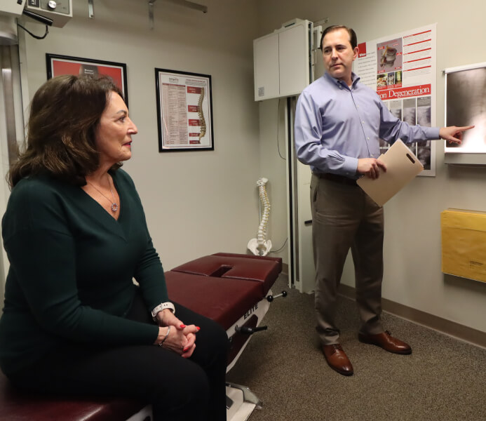 Chiropractor talking to patient
