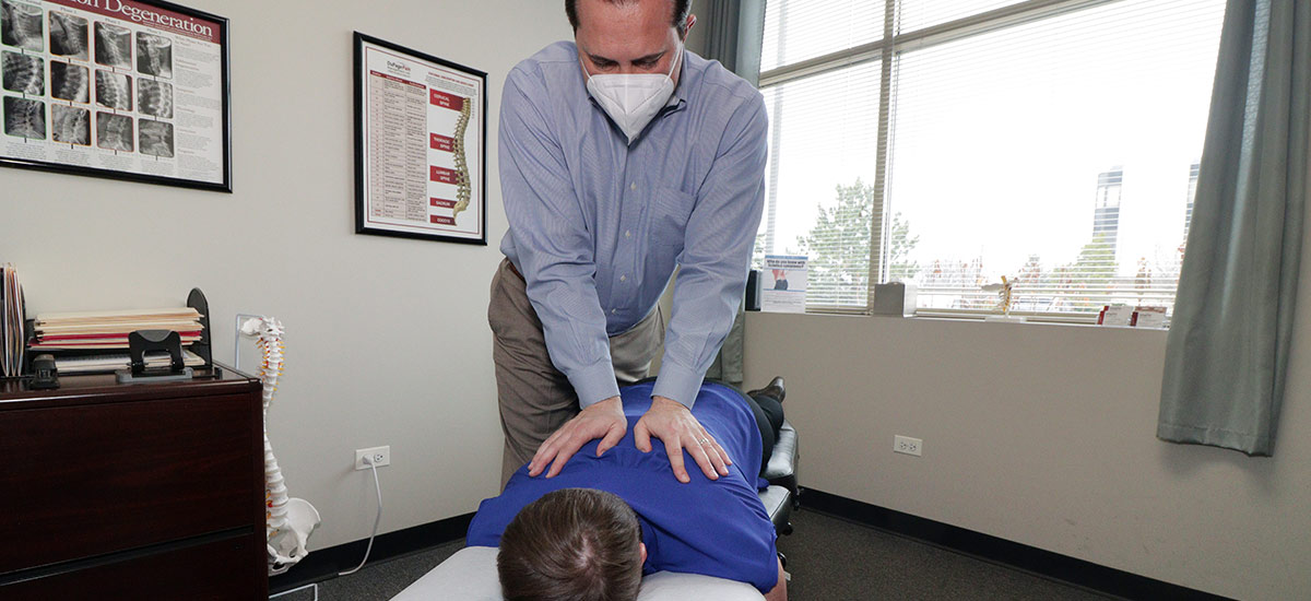 dr chris adjusting a patient's back