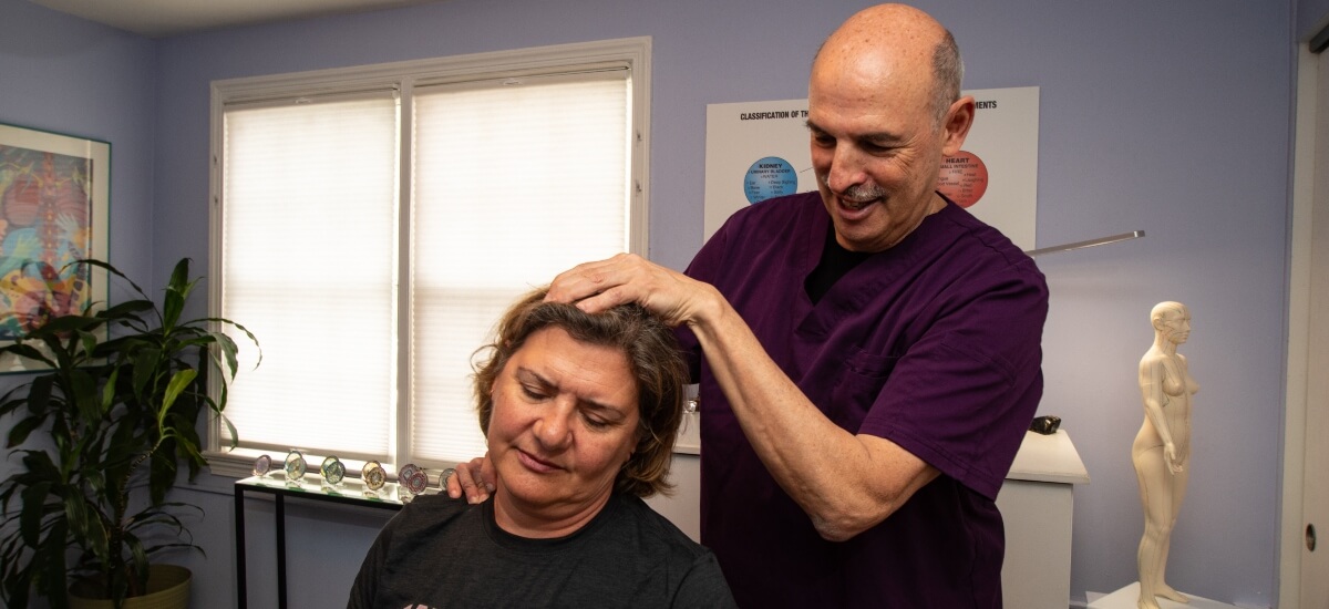 Alexandria chiropractor adjusting a patient's neck