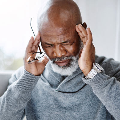 man touching his temples with headache pain