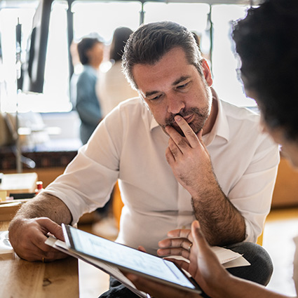 man looking at tablet during consultation