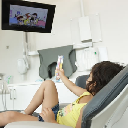 little girl watching tv while in chair