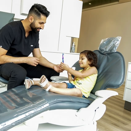 Dr Paul showing little girl toothbrush