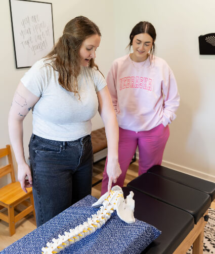 Chiropractor pointing at spine model