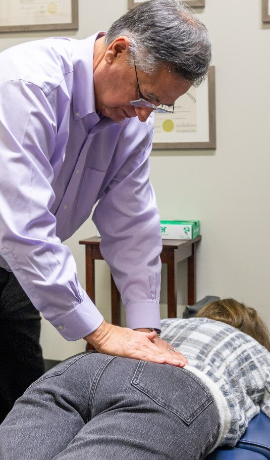 Sedalia chiropractor Dr Longie adjusting patients back