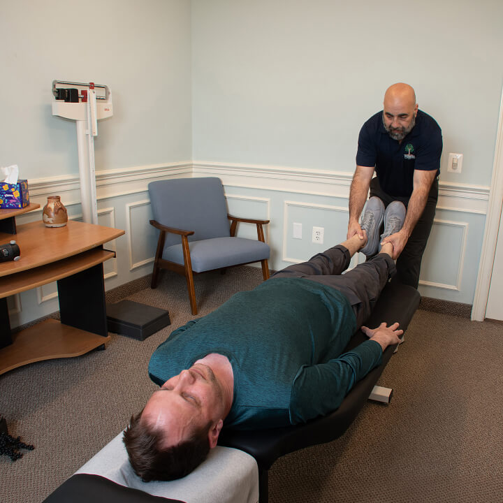 Triandos Chiropractic and Acupuncture patient having legs examined by our chiropractor