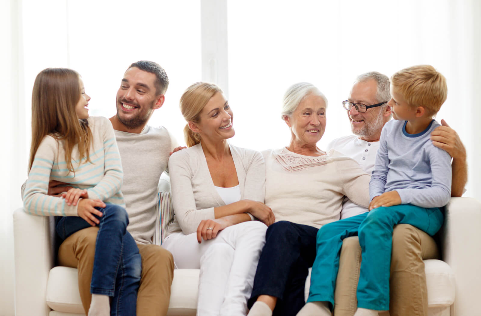 multigenerational family sitting on couch together smiling
