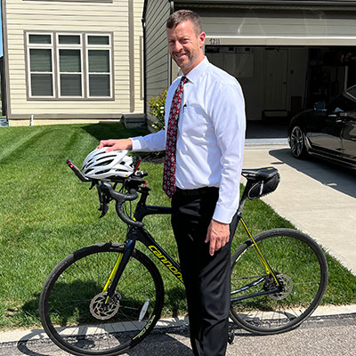 Dr Reid standing with his bike