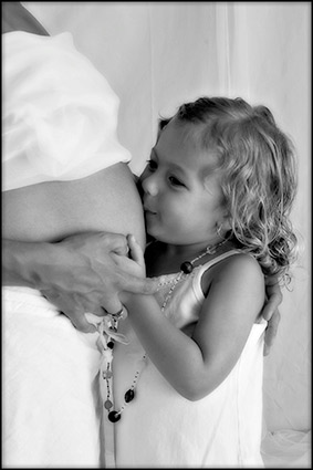 Girl kissing pregnant belly