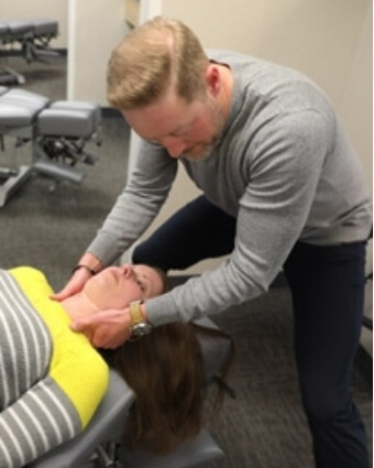 Dr. Cahill adjusting female patient
