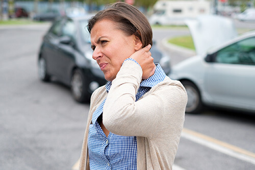 Woman holding neck after auto accident