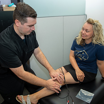 Dr. Nicholas Kirton performing therapy on patient's knee