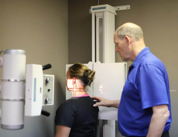 Female Inver Grove Heights patient being assisted with x-ray at Cahill Back & Neck Care Center