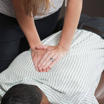 female-chiro-adjusts-back-sq-400