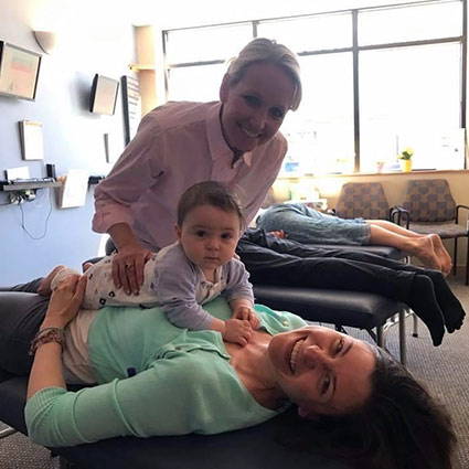mom and baby smiling during chiropractic adjustment